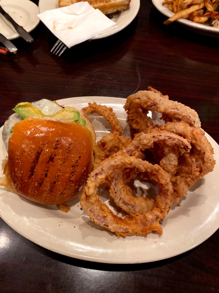 Image of an order of onion rings and a burger.